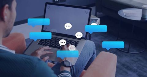 Man typing on laptop with floating chat bubbles in cozy lounge for remote messaging