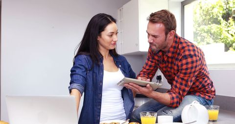 Couple Enjoying Breakfast While Watching Tablet in Modern Kitchen - Download Free Stock Images Pikwizard.com