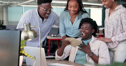 Team Celebrating Success as Colleague Receives Good News in Office