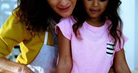 Mother Teaching Young Daughter Baking Skills in Kitchen Setting