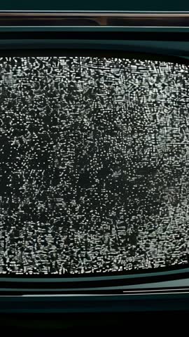 Vertical video zooming into monochrome static on vintage CRT television with flicker and grain