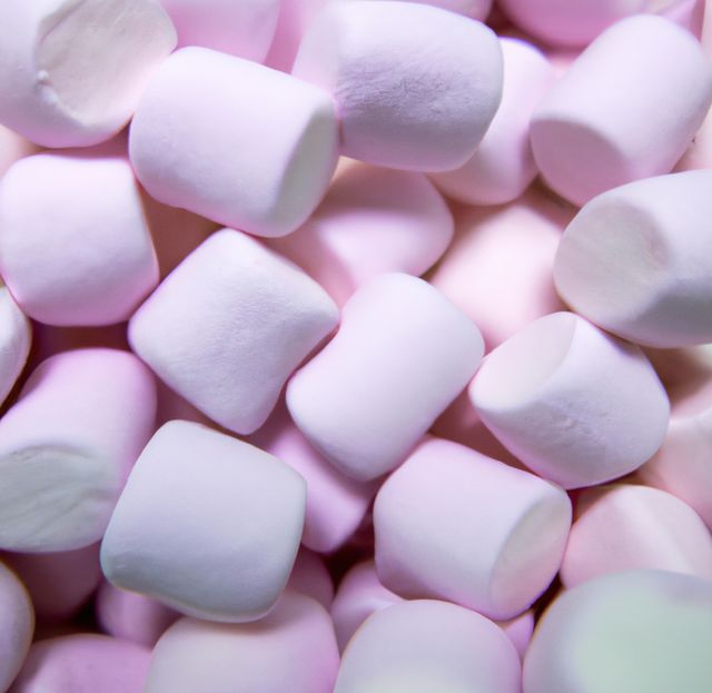 Close up of multiple pink marshmallows lying on black background. Sweets, food and drink concept.