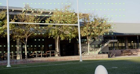White Football on Tee at Campus Turf with Goalposts, Green Marker Lights and Copy Space