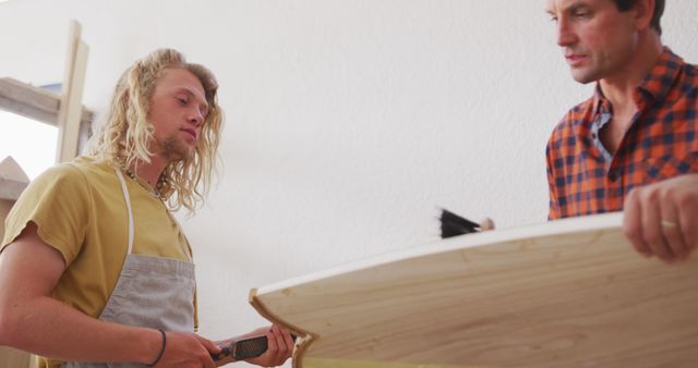 Two Male Craftsmen Working on Wooden Surfboard - Download Free Stock Images Pikwizard.com