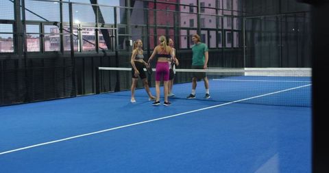 Friends Meeting on Glass-Walled Padel Court After Match