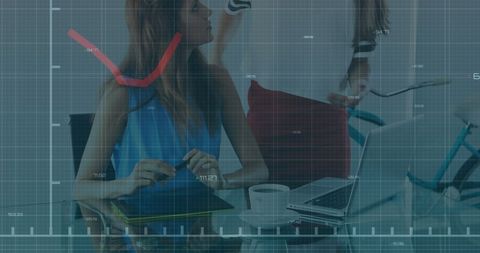 Businesswomen analyzing financial graphs on laptop in modern office