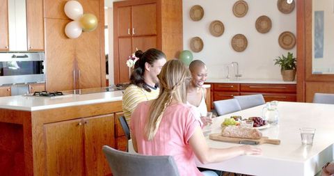 Friends Enjoying Social Gathering Around Kitchen Island