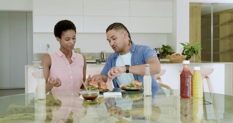 Diverse Couple Sharing Meal in Modern Kitchen Setting