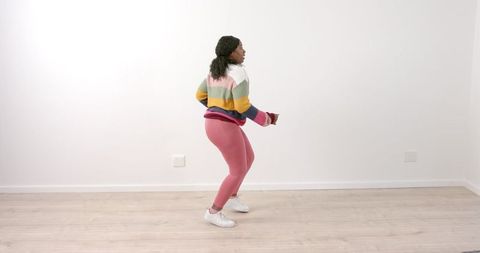 Woman dancing energetically in colorful sweater