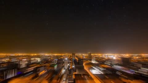 Dynamic Urban Nightscape View with Illuminated Streets and Stars