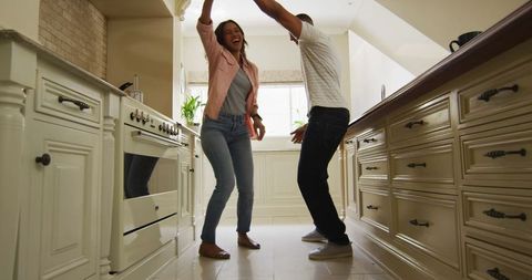 Joyful Couple Dancing in Cozy Kitchen, Expressing Love and Happiness
