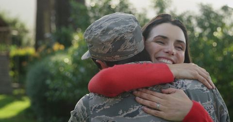 Soldier Homecoming Embraced by Smiling Woman in Garden - Download Free Stock Images Pikwizard.com
