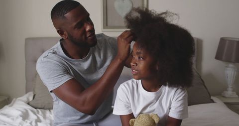 Father Gently Styling Daughter's Hair at Home