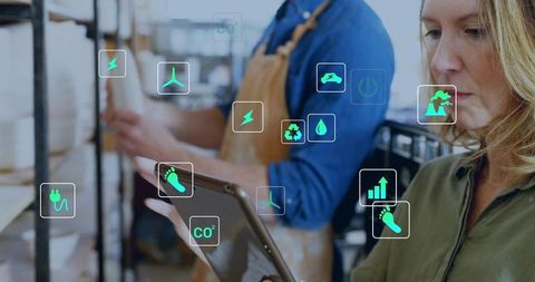 Mature warehouse manager using tablet monitoring sustainability and inventory analytics