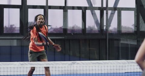 Athlete Focuses on Padel Tennis Gameplay in Indoor Court