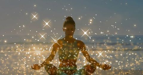 Woman Meditating on Beach at Sunrise with Sparkling Bokeh and Star Flares for Wellness