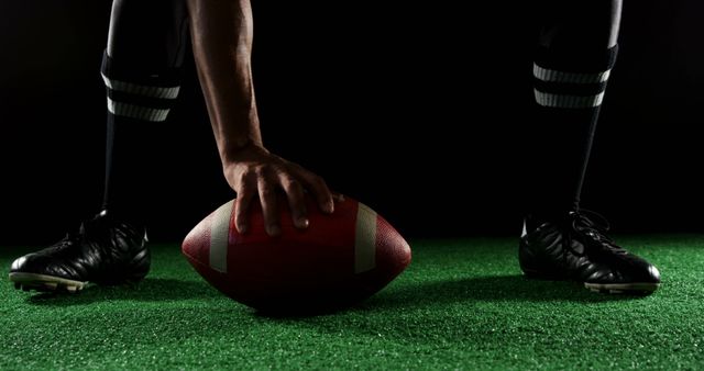 Close-up of american football player bending holding a ball on turf with his hands  - Download Free Stock Photos Pikwizard.com