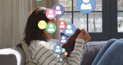 Woman reading with digital social media icons at home