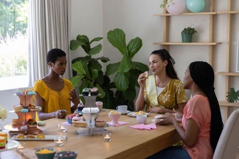 Diverse Female Friends Enjoying Cupcakes and Conversation at Home