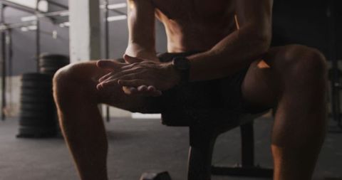 Man Rubbing Chalk in Hands on Bench in Gym Weightlifting Area