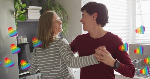 Joyful LGBTQ Lesbian Couple Dancing in Kitchen