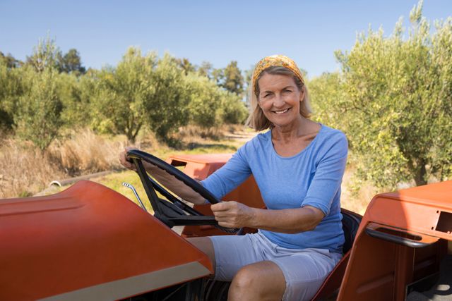 Portrait of happy woman sitting in tractor on a sunny day