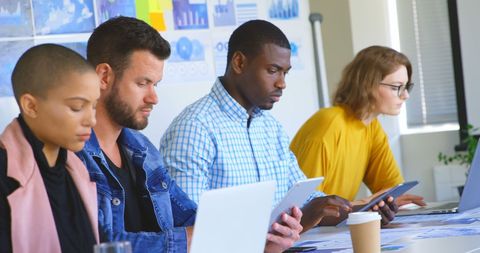 Diverse Business Team Collaborating on Digital Devices in Office