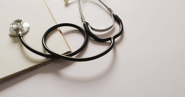 This image depicts a stethoscope lying on an open book with blank pages. Ideal for medical, healthcare, or educational content and can be used for websites, blogs, or articles related to medicine, science, and healthcare studies.