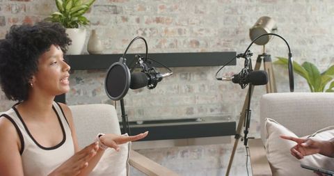 African american cohosts speaking and recording interview in cozy home podcast studio