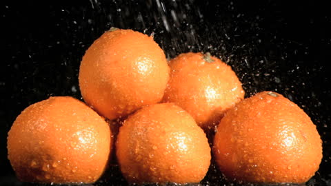 Fresh Oranges Splashing in Slow Motion on Black