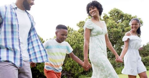 Happy Family Walking Together in Sunny Park