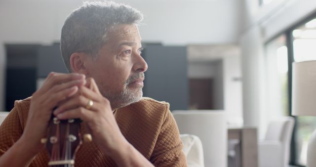 Pensive Man Holding Guitar in Living Room - Download Free Stock Images Pikwizard.com