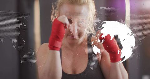 Female boxer training with red hand wraps and digital world map overlay
