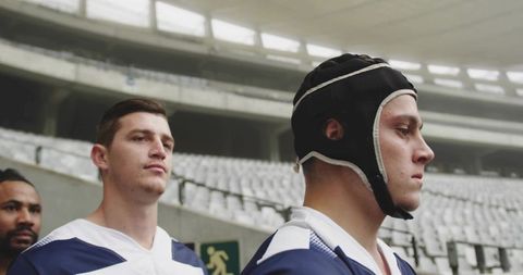 Focused rugby team lining tunnel wearing headgear and blue-white jerseys preparing for kickoff
