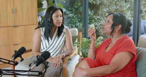 African american women recording cozy home podcast interview while senior woman shares story