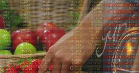 Reaching hand selecting fresh strawberries at farmers market with financial data overlay