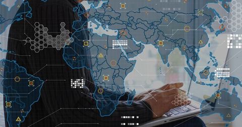 Mature executive typing on laptop with global data map overlay and analytics dashboard