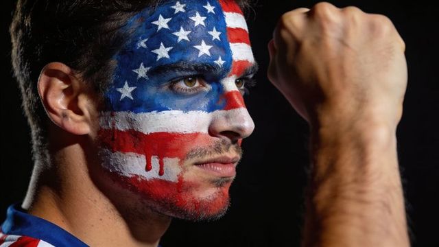 Clenching fist patriotic fan with american flag face paint dramatic closeup
