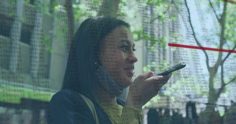 Midadult professional speaking into smartphone with digital data overlay in urban plaza