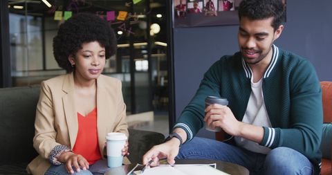 Diverse Professionals Discussing Paperwork in Modern Office Setting
