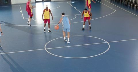 Athlete Dribbling Basketball on Indoor Court Under Lights