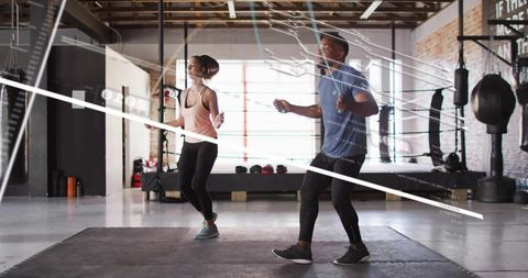 Jumping rope partners in industrial boxing gym for functional cardio and hiit training