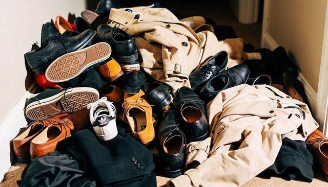 Overloaded entryway piling shoes and coats cluttering hallway with white sneaker detail