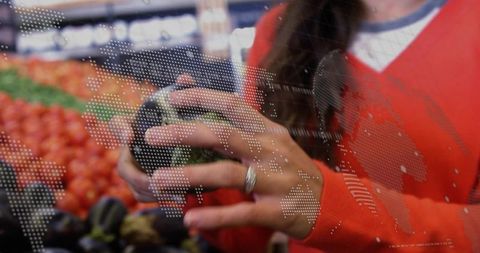 Woman Choosing Fresh Vegetable in Supermarket with Global Market Overlay
