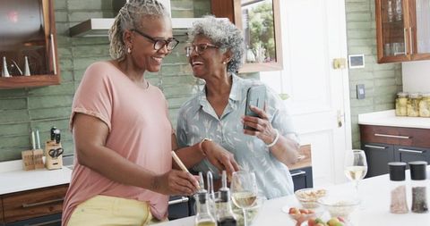Senior African American Women Enjoy Cooking Together in Modern Kitchen
