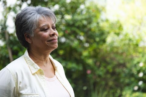 Senior Woman Enjoying Nature in Tranquil Garden Setting