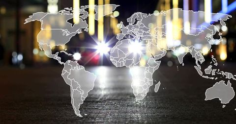 Global map overlaying urban street at night reflecting headlights and neon bokeh
