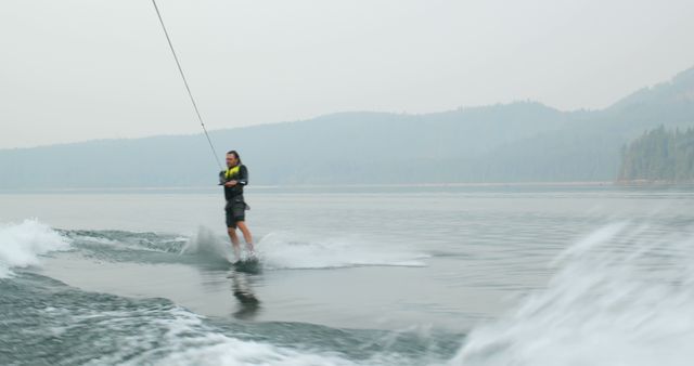 Woman Wakeboarding on Misty Lake - Download Free Stock Images Pikwizard.com