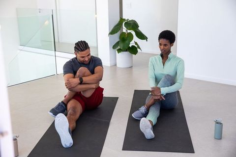 Diverse Friends Bonding Through Stretching and Fitness in Modern Space