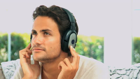 Man Enjoying Music with Headphones Indoors Confidently